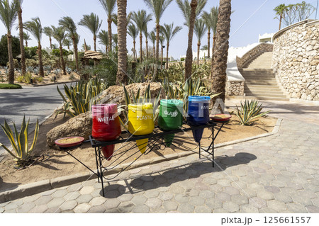 Color-coded recycle bins in Egypt hotel resort dedicated to separate waste collection for plastic glass metal and paper highlighting recycling and environmental responsibility. Environmental concept. 125661557