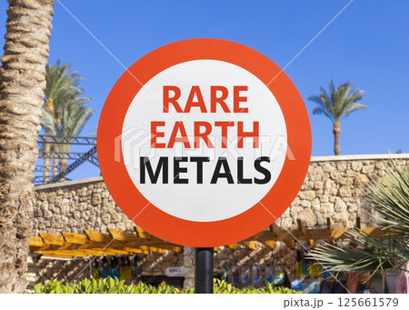 Rare earth metals symbol. Concept words Rare earth metals on beautiful big white road sign. Beautiful palm tree hotel blue sky background. Business and rare earth metals concept. Copy space. 125661579