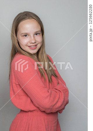 Joyful young child girl standing against white wall background Joyful young child girl standing against white wall background 125662280