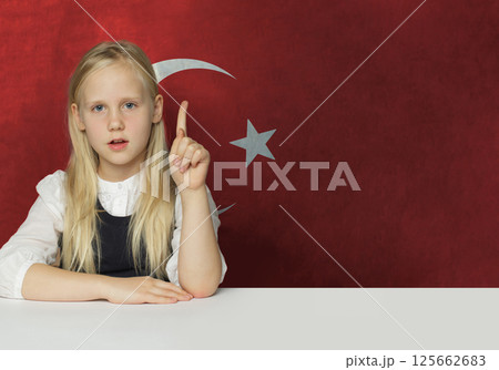 Clever young child girl pointing up on flag of Turkiye background. Education and study  125662683