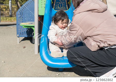 【相模原市立麻溝公園の子どもの広場でママと遊ぶ1歳児】 125662802