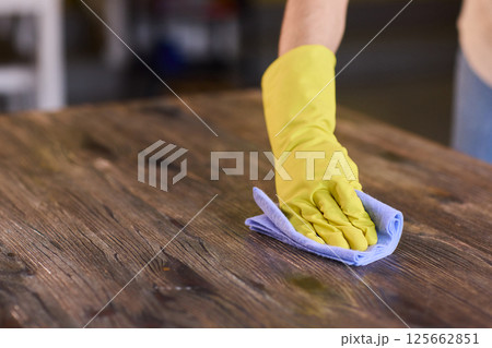 Effectively Cleaning A Table Surface With A Sponge For A Neat And Tidy Appearance 125662851