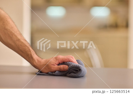 Performing the task of cleaning surfaces with a cloth for a fresh and polished look Performing the task of cleaning surfaces with a cloth for a fresh and polished look 125663514
