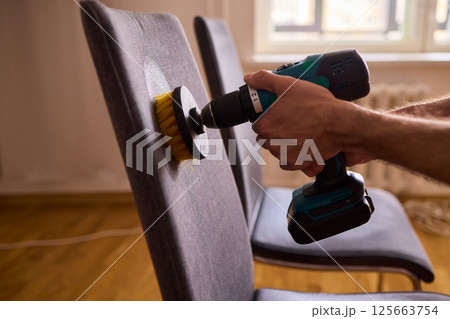 Effective Upholstery Cleaning Using a Power Tool on a Beautiful Sofa for the Best Results 125663754