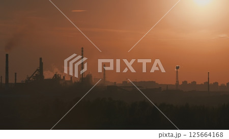 A mesmerizing Industrial Landscape at Sunset featuring Smokestacks and visible Pollution 125664168