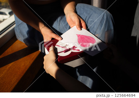 Children girl congratulating mom and giving postcard for mother's day, 8 march, birthday. Children girl congratulating mom and giving postcard for mother's day, 8 march, birthday. 125664694