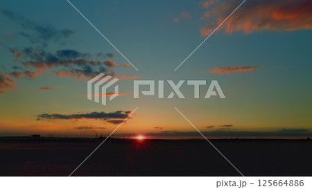 Experience the breathtaking sunset over a serene landscape that captivates the soul 125664886