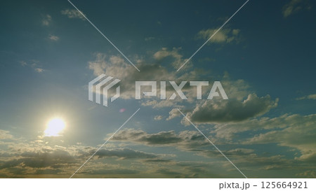 The Serene Clouds and Bright Sunlight Spread Over the Distant Horizon During Daylight The Serene Clouds and Bright Sunlight Spread Over the Distant Horizon During Daylight 125664921
