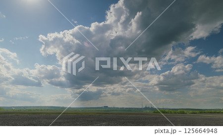 A picturesque and scenic cloudy sky gracefully spreads over the lush green fields below A picturesque and scenic cloudy sky gracefully spreads over the lush green fields below 125664948