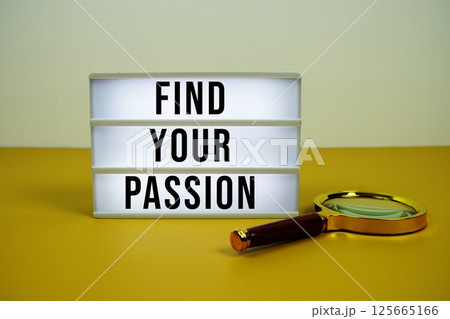 Find Your Passion text on LED lightbox with magnifying glass on yellow background 125665166