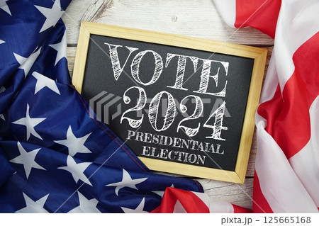 American flag with Presidential election 2024 text top view on wooden background 125665168