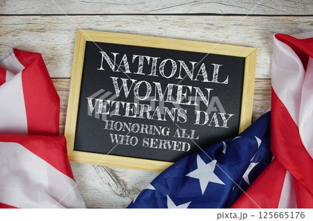 National Women Veterans Day text message with USA flag on wooden background, America national holiday concept National Women Veterans Day text message with USA flag on wooden background, America national holiday concept 125665176