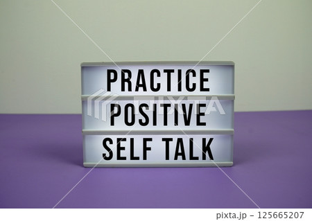 Practice Positive Self Talk text on light box on purple background 125665207