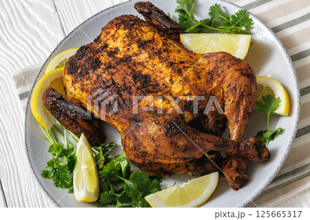 whole crispy skin roasted chicken on a platter whole crispy skin roasted chicken on a platter 125665317