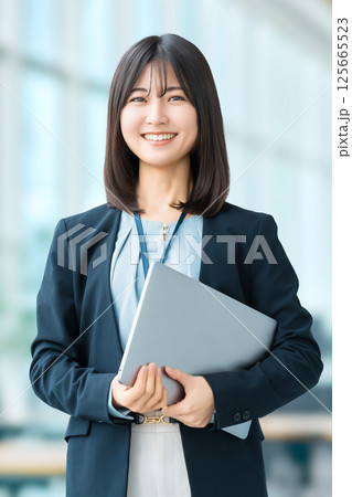 ノートパソコンを持つ笑顔の女性・ビジネスウーマン 125665523
