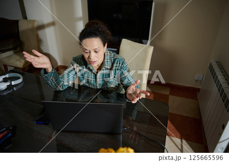 Woman Engaged in Virtual Communication in Home Office Environment Woman Engaged in Virtual Communication in Home Office Environment 125665596