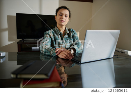 Confident Woman Working Remotely at Home Office with Laptop 125665611