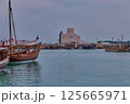 Museum of Islamic Art in Doha, Qatar daylight view with Dhows in Arabic gulf with Qatar flag in foreground 125665971