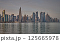 Doha Qatar skyline from corniche promenade sunset shot showing dhows in Arabic gulf with Qatar flag 125665978