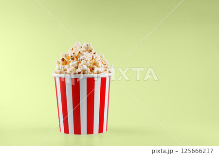Classic red striped popcorn cardboard cup on Green background Classic red striped popcorn cardboard cup on Green background 125666217
