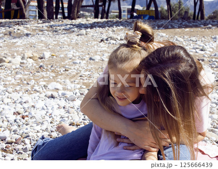 mother with twins daughters on beach mother with twins daughters on beach 125666439