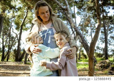 young mother with twins daughters outside having fun 125666445