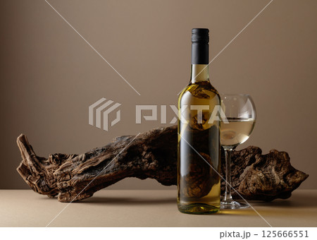 White wine and old snag on a beige background. 125666551