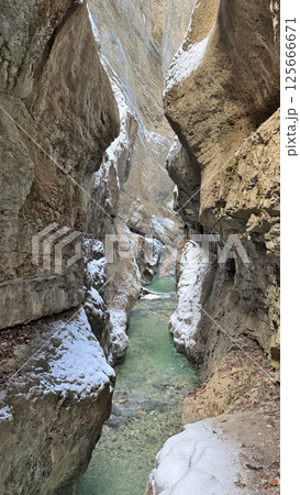 Majestic narrow Bayern Partnach Gorge with flowing water, snow-covered rocks natural beauty concept 125666671