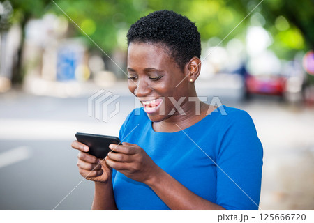 Close-up of young girl with mobile phone, happy. 125666720