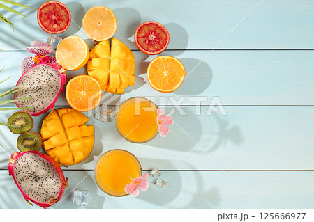 Summer party concept. Sunny tropical flyer, background with cocktails and juices from citrus, dragon fruit and mango. Exotic fruits and orchid flowers on a bright background. Business card for a bar Summer party concept. Sunny tropical flyer, background with cocktails and juices from citrus, dragon fruit and mango. Exotic fruits and orchid flowers on a bright background. Business card for a bar 125666977
