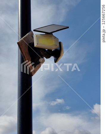 solar-powered light fixture mounted on pole cloudy sky background in an outdoor location. close up. 125667256