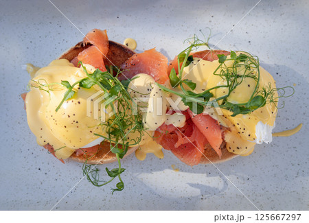 Eggs Royale made with english muffin, oak smoked salmon, a brace of poached hen's eggs & hollandaise sauce and watercress. 125667297