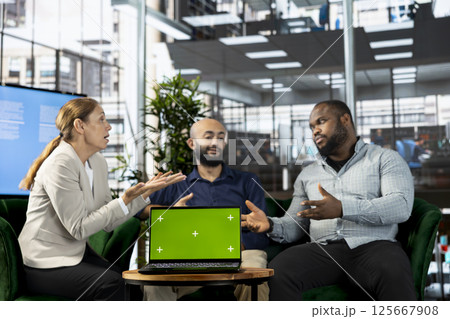 Isolated screen notebook next to multiethnic team working in office, coordinating company administrative operation. Diverse coworkers reviewing business data metrics on chroma key laptop Isolated screen notebook next to multiethnic team working in office, coordinating company administrative operation. Diverse coworkers reviewing business data metrics on chroma key laptop 125667908