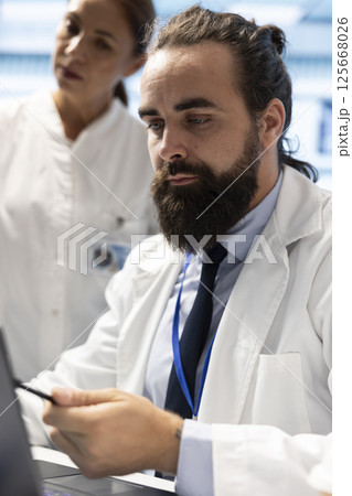 Radiologists review human anatomy scans to develop effective treatment plan. Teamwork and expertise in radiology, analytics and diagnostics ensuring comprehensive healthcare solutions. Radiologists review human anatomy scans to develop effective treatment plan. Teamwork and expertise in radiology, analytics and diagnostics ensuring comprehensive healthcare solutions. 125668026