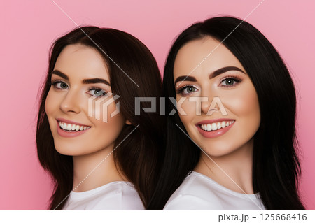 Portrait of smiling women with brunette hair on pink background showcasing beauty and joy Portrait of smiling women with brunette hair on pink background showcasing beauty and joy 125668416