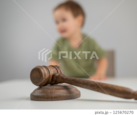 Little boy behind judge's gavel.  125670270