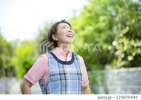 ベテラン介護士や保育士のイメージ笑顔で見上げる ベテラン介護士や保育士のイメージ笑顔で見上げる 125670494