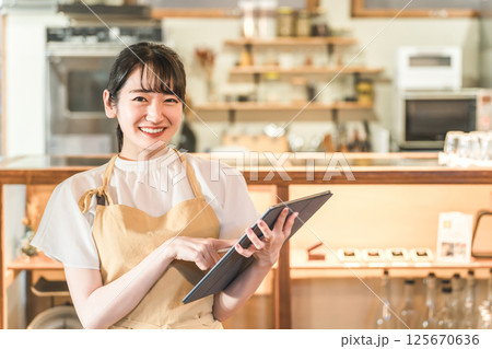 タブレットで注文を確認するレストランスタッフ（アルバイト,バイト,ウェイトレス） 125670636