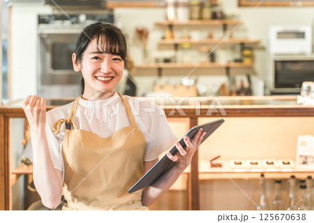 タブレットで注文を確認するレストランスタッフ（アルバイト,バイト,ウェイトレス） 125670638