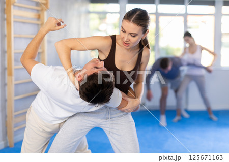 Young girl applying throwing technique on her opponent in sports hall Young girl applying throwing technique on her opponent in sports hall 125671163