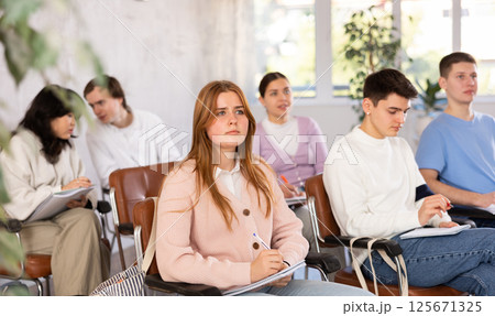 Young female student listening to lecture with focus 125671325