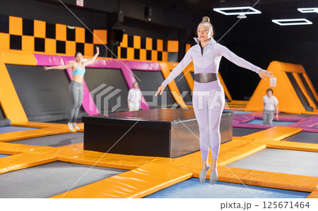 Portrait of sporty fit woman enjoying weekend while spending time on trampolines in game club indoors Portrait of sporty fit woman enjoying weekend while spending time on trampolines in game club indoors 125671464