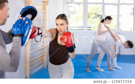 Young woman training in boxing fight in studio Young woman training in boxing fight in studio 125671558