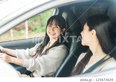 車を運転する女性と助手席に乗る女友達（ドライバー,ドライブ） 125673029