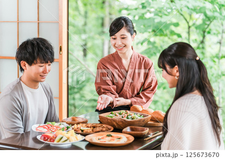 温泉旅館の客室で料理の説明をする旅館スタッフ・仲居さんの女性 125673670