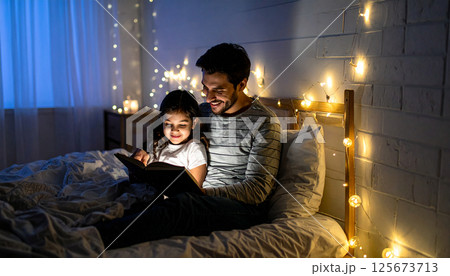 Dad and daughter reading a book together under a warm light. Generated image 125673713