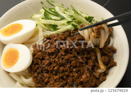 肉味噌うどんを箸で持ち上げる 125674029