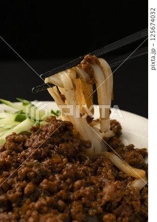 肉味噌うどんを箸で持ち上げる 125674032