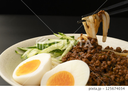 肉味噌うどんを箸で持ち上げる 125674034