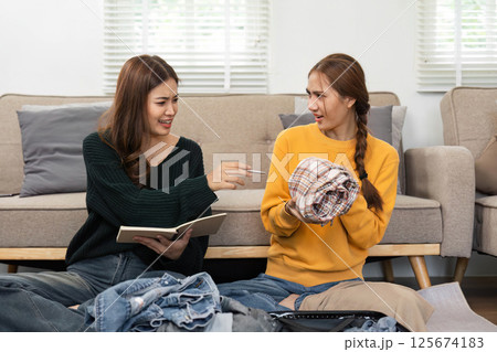Travel Packing Moments: Friends Joyfully Preparing a Suitcase 125674183